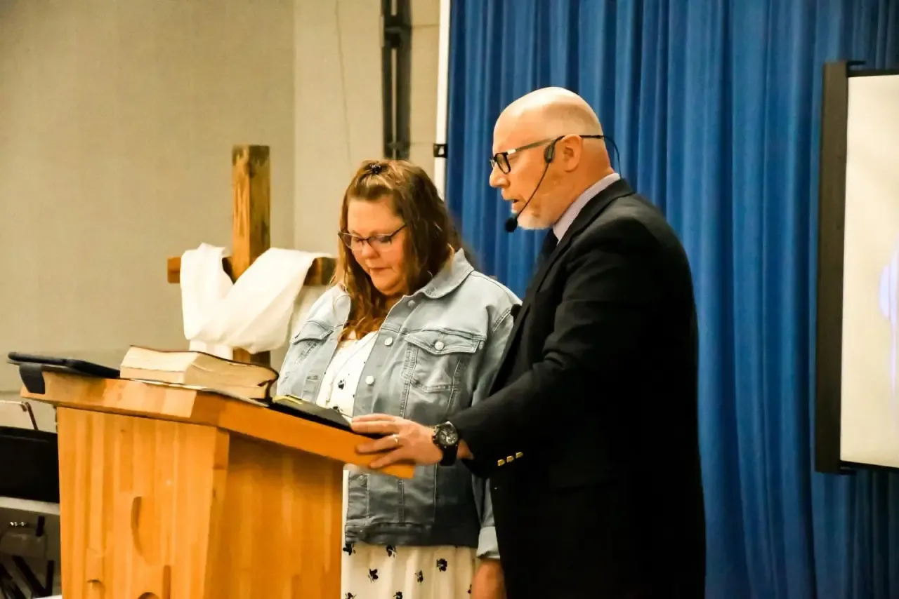 Pastor Mike and Linda Mattox praying at the pulpit